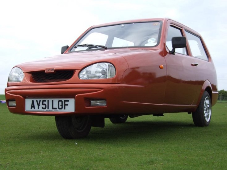 2002 Reliant Robin, 3 kerekű, 2 ajtós hatchback, narancssárga, elölnézet, oldalnézet, balról döntve, alulról fotózva