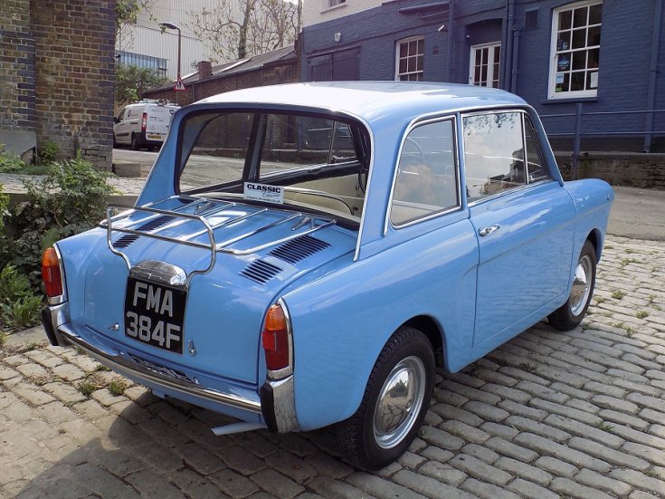 1967 Autobianchi Bianchina Berlina, kék 2 ajtós limuzin, hátulnézet, oldalnézet, jobbról döntve, alulról fotózva, háttérben régi épületek