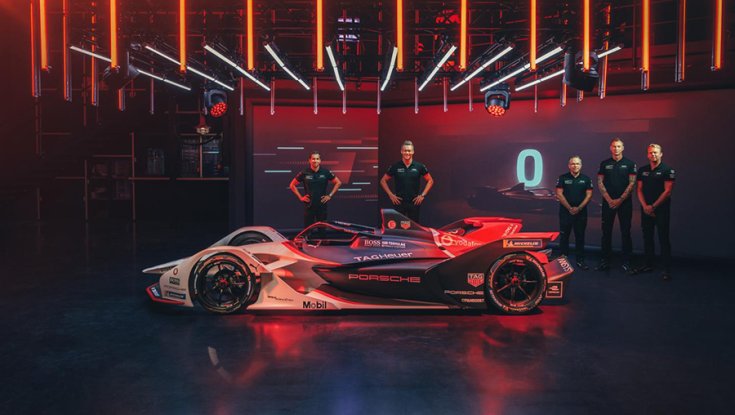 A Porsche 99X Electric oldalról fotózva mögötte a csapat