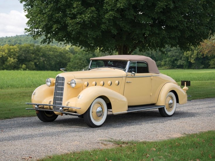 1934 LaSalle Series 50, sárga kabrió, elölnézet, oldalnézet, balról, távolról ráközelítve, háttérben mező és fák