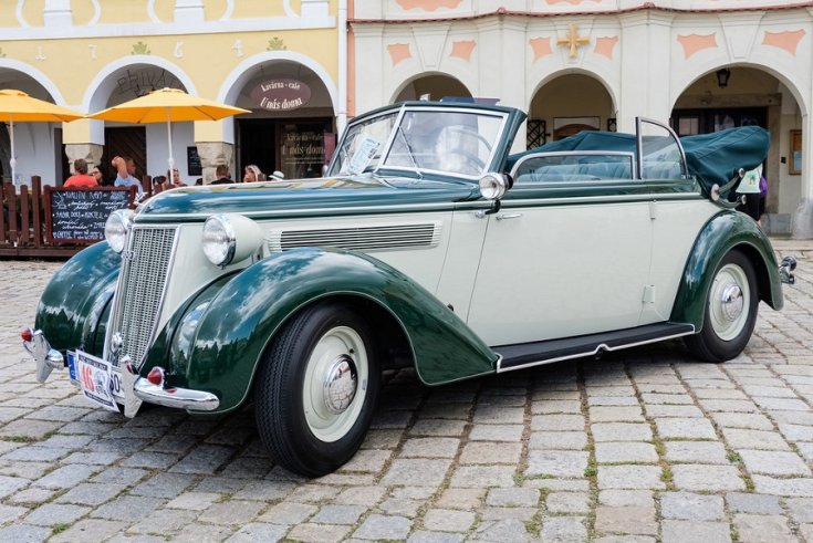 1939 Wanderer W23, 2 tónusú kabrió lehúzott tetővel, zöld és fehér, elölnézet, oldalnézet, balról döntve, háttérben egy tér emberekkel