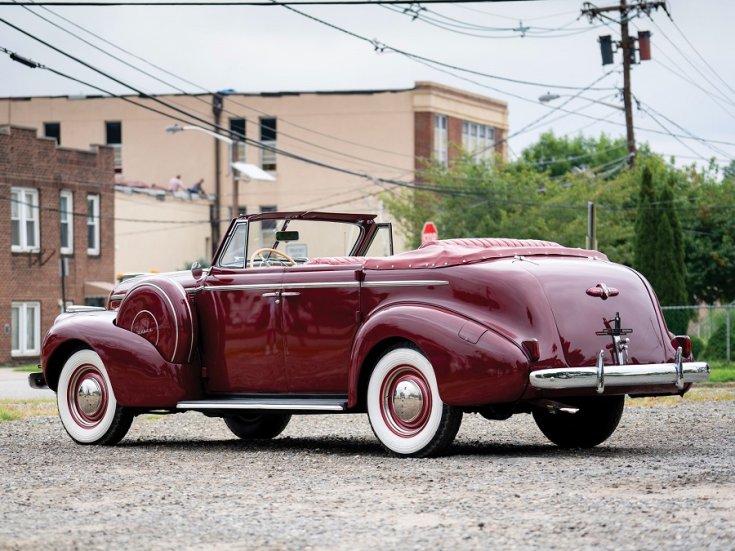 1940 Buick Special Sport Phaeton, meggyvörös kabrió limuzin, hátulnézet, oldalnézet, balról, alulról fotózva, háttérben fák és téglaházak