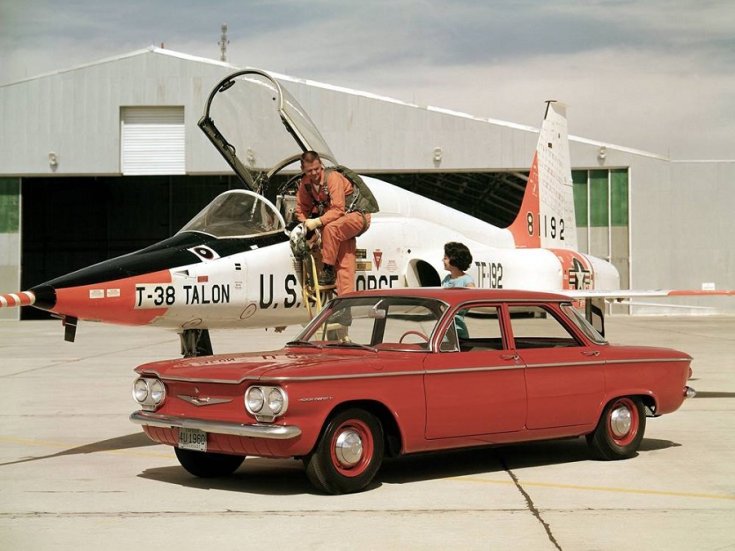 960 Chevrolet Corvair, vörös szedán, elölnézet, oldalnézet, balról döntve, távolról ráközelítve, háttérben hangár és harci repülő