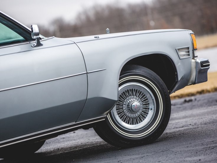 1976 Oldsmobile 98 Regency, ezüstszínű limuzin, jobb első kerék és sárhányó, oldalnézet, jobbról