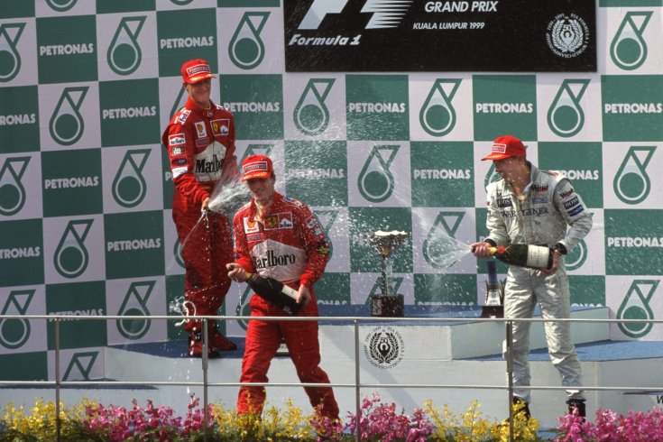 Irvine, Häkkinen és Schumacher pezsgőzik az 1999-es Maláj Nagydíj dobogóján