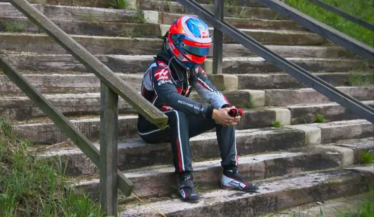 Grosjean egy lépcsőn mereng, miután kiesett a biztonsági autó mögött a 2018-as Azeri Nagydíjon