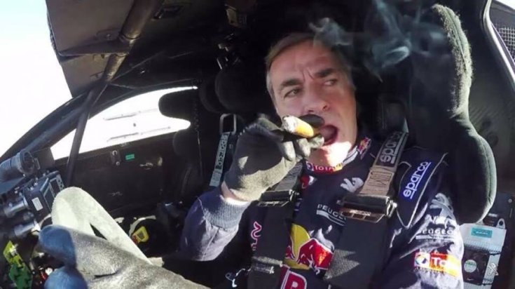 Carlos Sainz szivarozik a versenyautóban