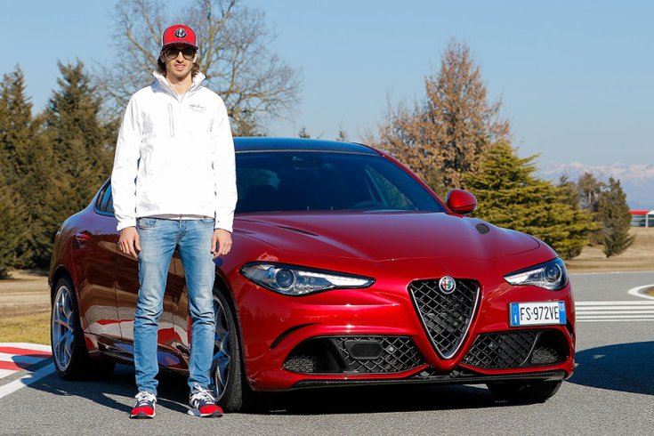 Antonio Giovinazzi az Alfa Romeo modellje mellett a Balocco tesztpályán