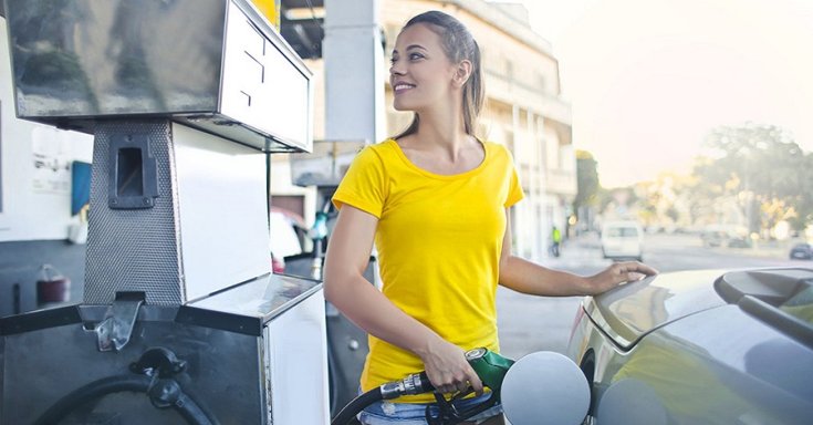 Mosolygós autós tankol üzemanyagot az autójába