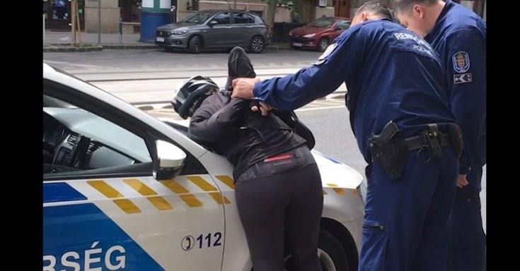 Biciklis nő a rendőrautó motorháztetején