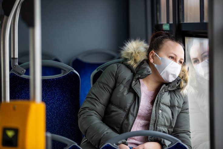 Szájmaszkot viselő hölgy utazik a buszon
