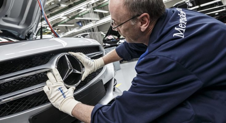 A Mercedes emblémáját illesztik a helyére egy gyárban