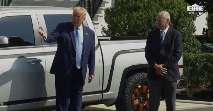 Donald Trump magyaráz egy elektromos kisteherautó mellett állva