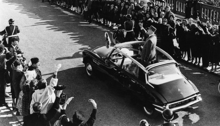 Charles De Gaulle francia elnök integet egy nyitott Citroen DS-ből egy felvonuláson