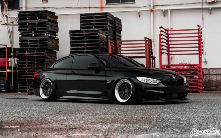 BMW 435i stance autó oldalról egy telepen, fekete színben