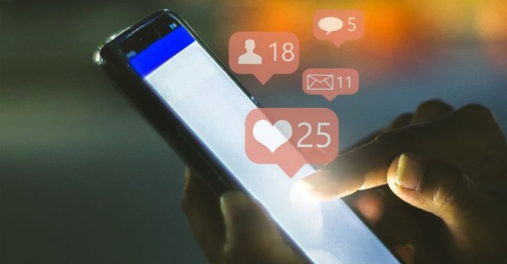 Facebook reakciók érkeznek, miközben egy férfi mobilját kezében tartja