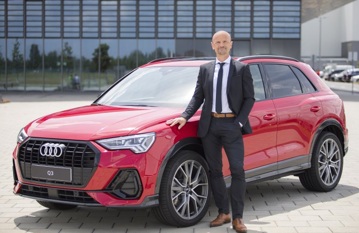 Les Zoltán áll egy Audi mellett