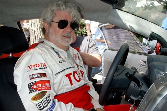 George Lucas egy versenyautó kormánya mögött oldalról