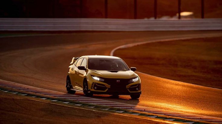 2021 Honda Civic Type-R limitált szériás modell sárga színben a suzukai versenypályán szemből, menet közben, naplementében