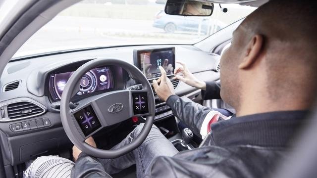 a sofőr és utatsa az infotainment képernyőt használja