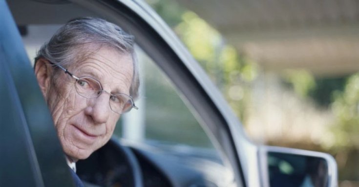 idős sofőr kinéz az ablakon hátrafelé