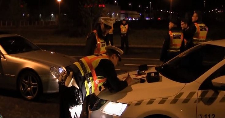 Rendőrök igazoltatnak egy sofőrt az éjszakai órákban