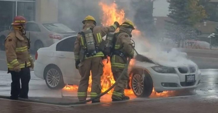 Égő BMW-t tűzoltók oltanak