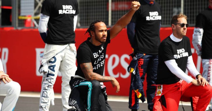 Lewis Hamilton egy verseny előtti We race as one térdelés során
