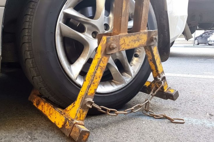 sárga színű kerékbilincs egy autón