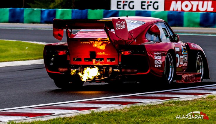 Porsche hátulról fotózva, miközben féktávon lövi a lángot