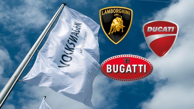 Volkswagen zászló lobog a szélben, mellette a Lamborghini, a Ducati és a Bugatti logója