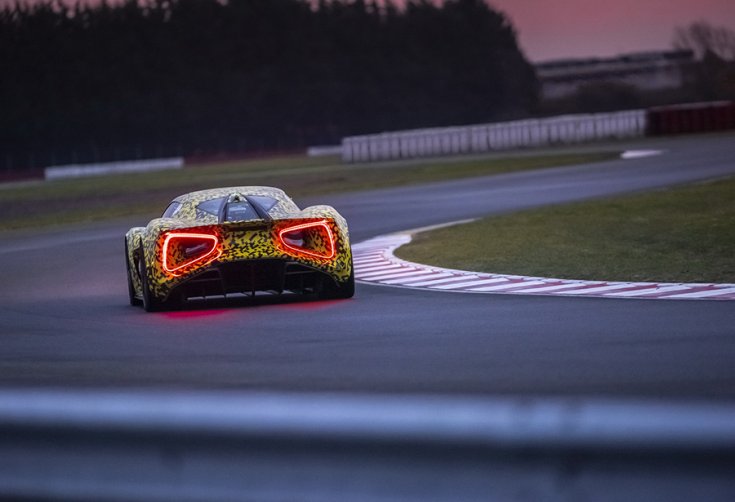 A Lotus Evija hátulról fotózva, világító lámpákkal