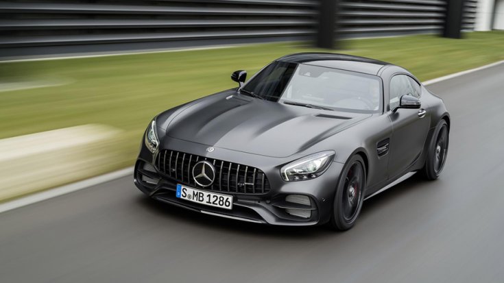 Egy szürke Mercedes-AMG GT C menetközben elölről negyvenöt fokból fotózva