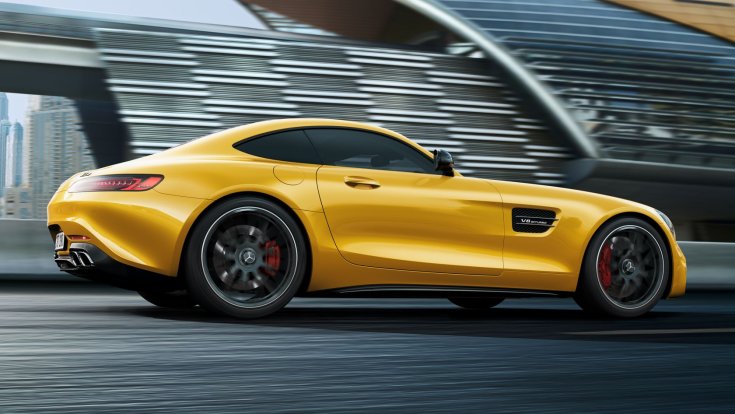 Sárga Mercedes AMG GT Coupe egy versenypályán, oldalról