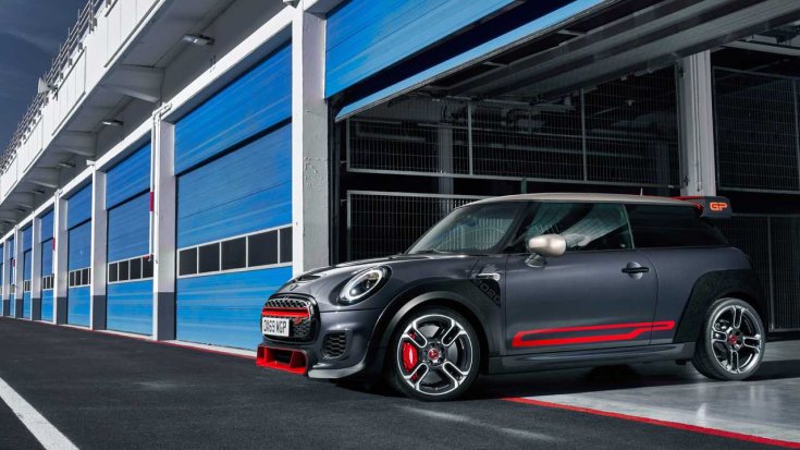 Szürke-piros Mini JCW GP, oldalról, egy versenypályája boxutcájában