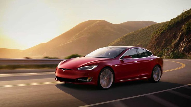 Model S egy hegyvidékes országúton, naplementében, féloldalról