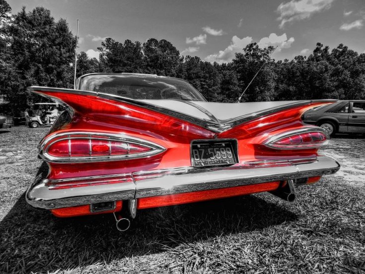 1959 Chevrolet Impala, fekete fehér kép, vörösre színezett autó, hátsó rész, oldalra döntve, balra