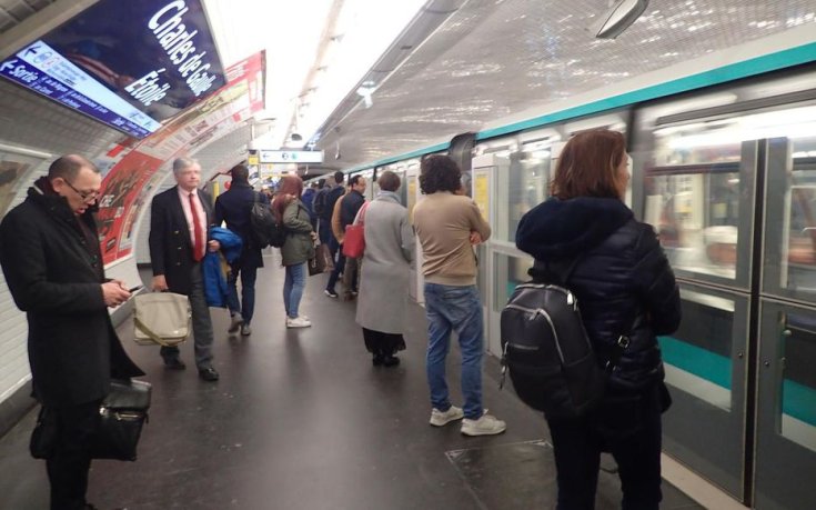 önvezető párizsi metróra várnak az utasok a megállóban