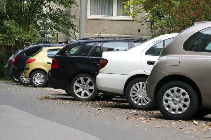 Panelház tövében parkoló autók