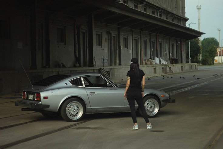 Rupa Adrienn autós újságíró Datsun S30 modell előtt állva, háttal