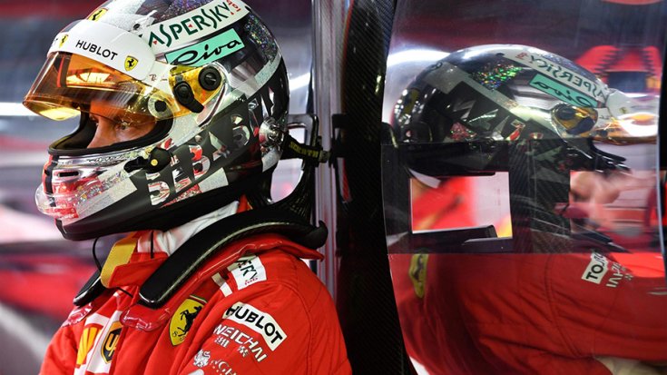 Sebastian Vettel a falnak támaszkodva oldalról fotózva