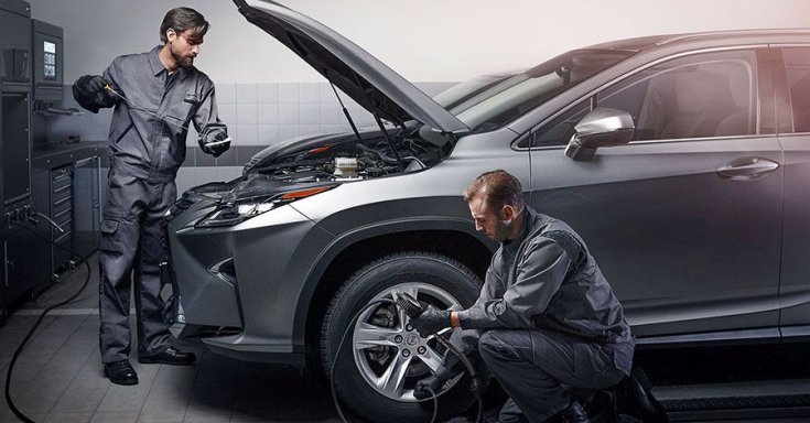 Autóműhelyben két szerelő dolgozik egy Lexus ES-n