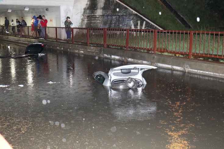 bámészkodók nézik a víz alá merült szolnoki autókat