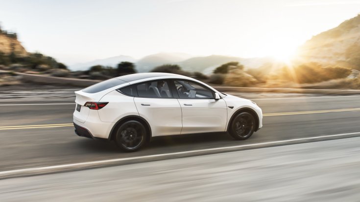 Tesla Model Y hátulról, menet közben, naplementében