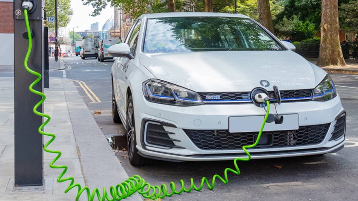 VW GTE töltés közben egy fix töltőnél, szemből fotózva