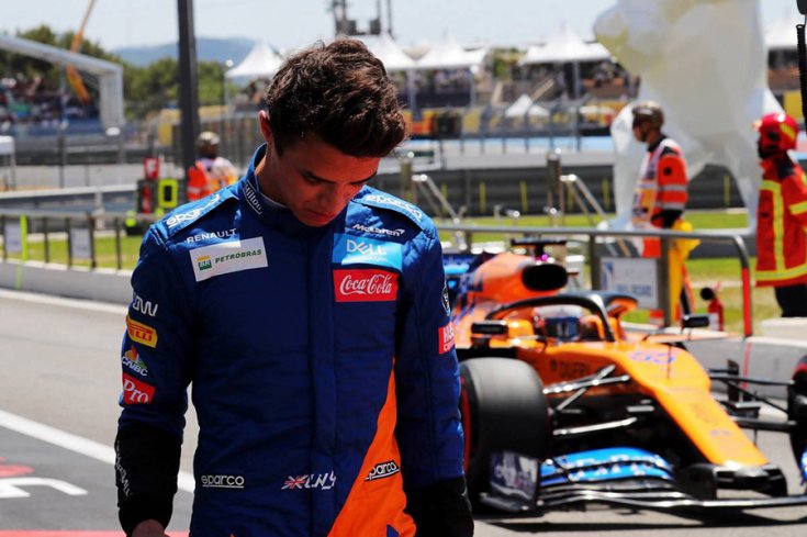 Lando Norris leszegett fejjel az autója mellett
