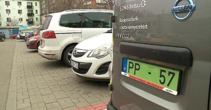 Zöld rendszámos Nissan áll egy helyben egy parkolóban